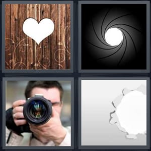 heart in wood wall, lens of camera opening, man holding camera taking photo, hole in piece of paper